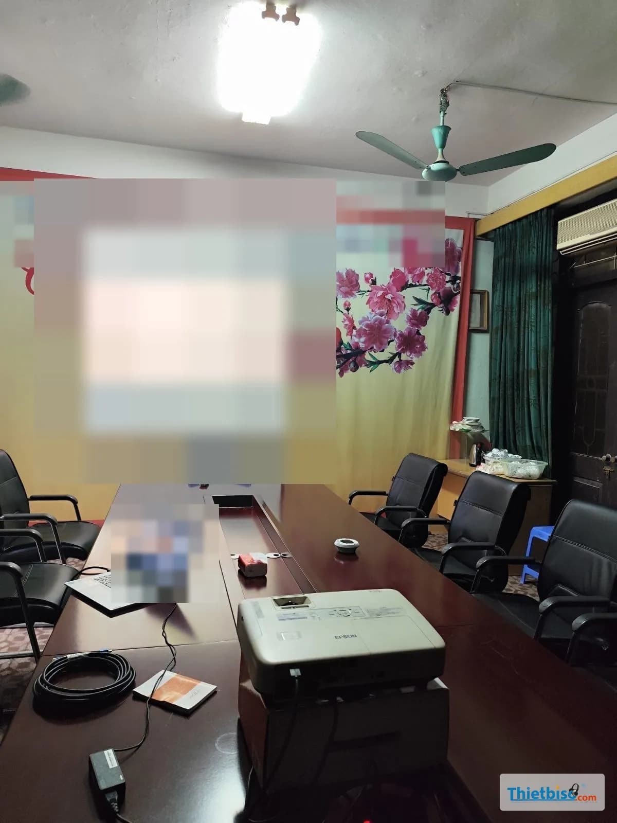 Toàn cảnh phòng họp ở Hà Đông với máy chiếu Epson trên bàn và màn treo tường đang chiếu bài báo cáo