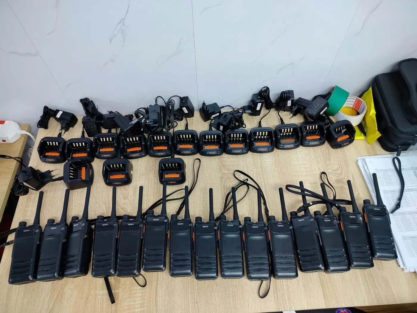 Một lô 15 bộ đàm Hytera và đế sạc xếp hàng