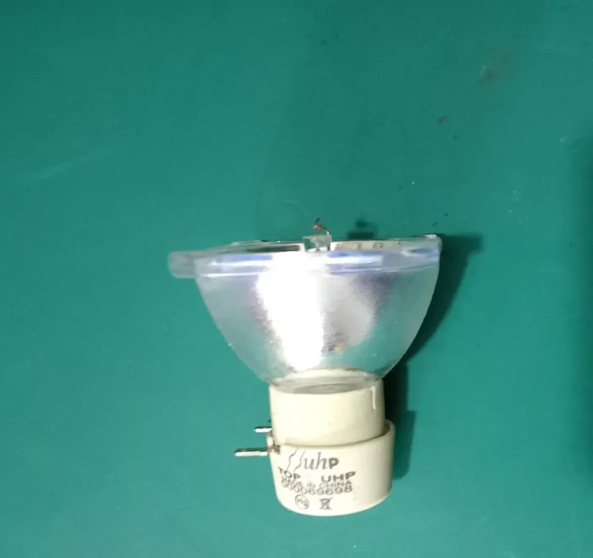Bóng đèn UHP đã tháo khỏi máy chiếu đặt trên bàn sửa