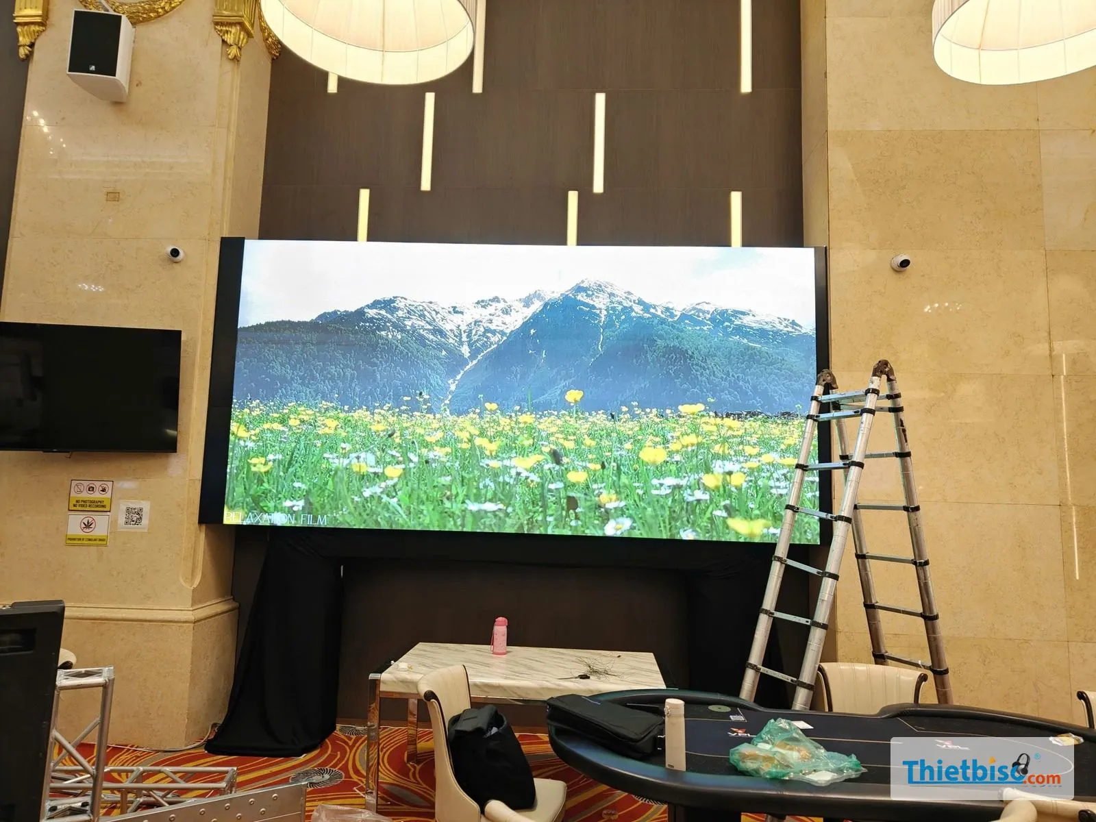 Màn LED đã lắp xong phát video đồng hoa, có loa treo và tivi bên trái