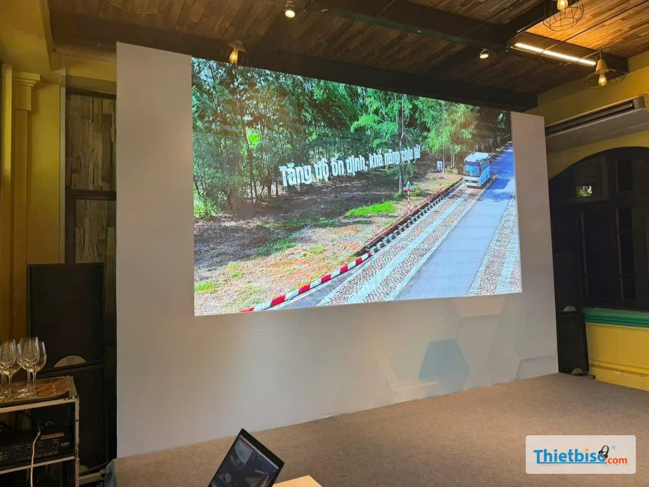 Màn LED trong nhà hiển thị hình ảnh xe bus, hai bên có loa