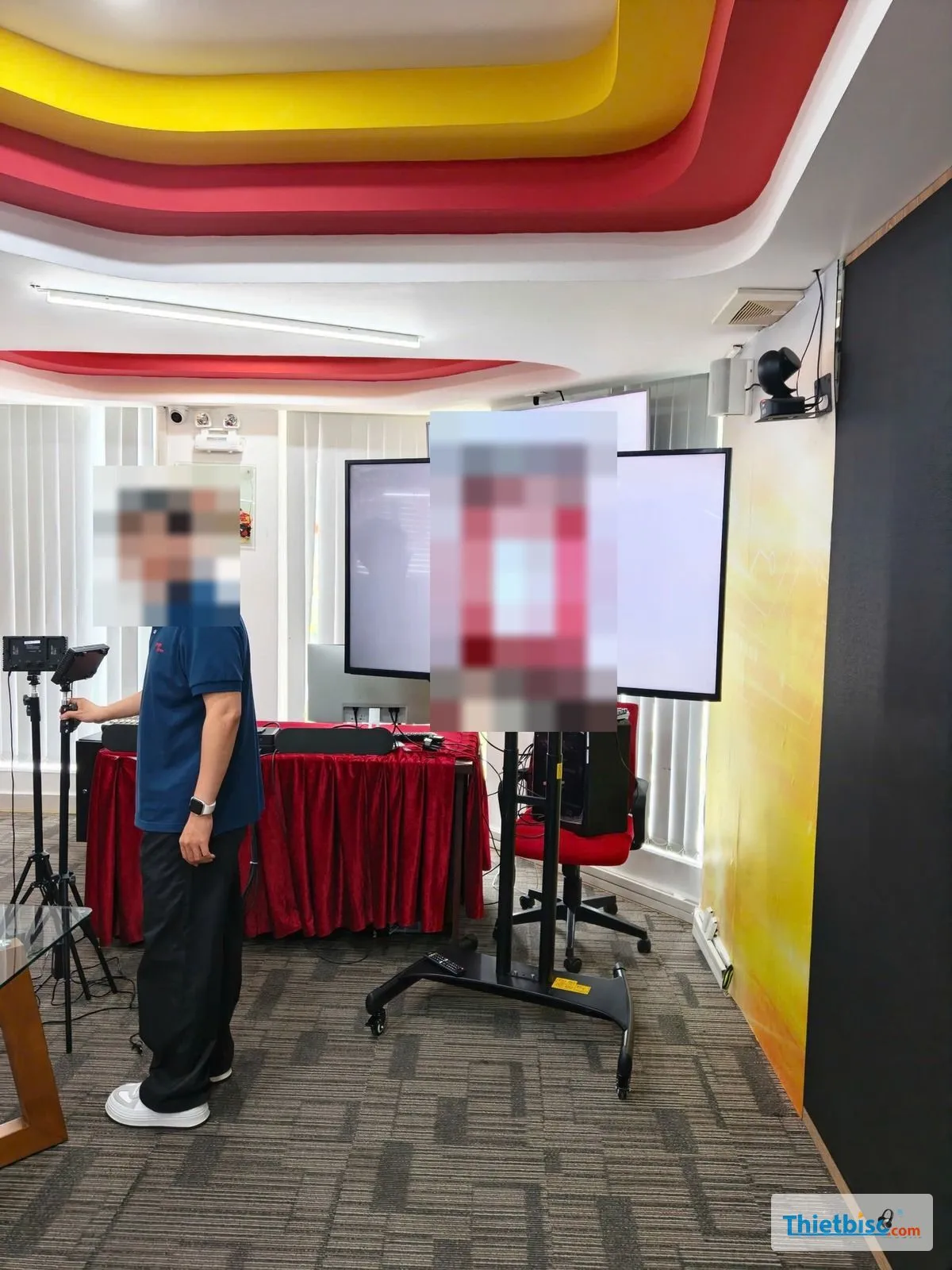 Tivi LG trên chân di động trong phòng có đèn quay phim và camera treo tường