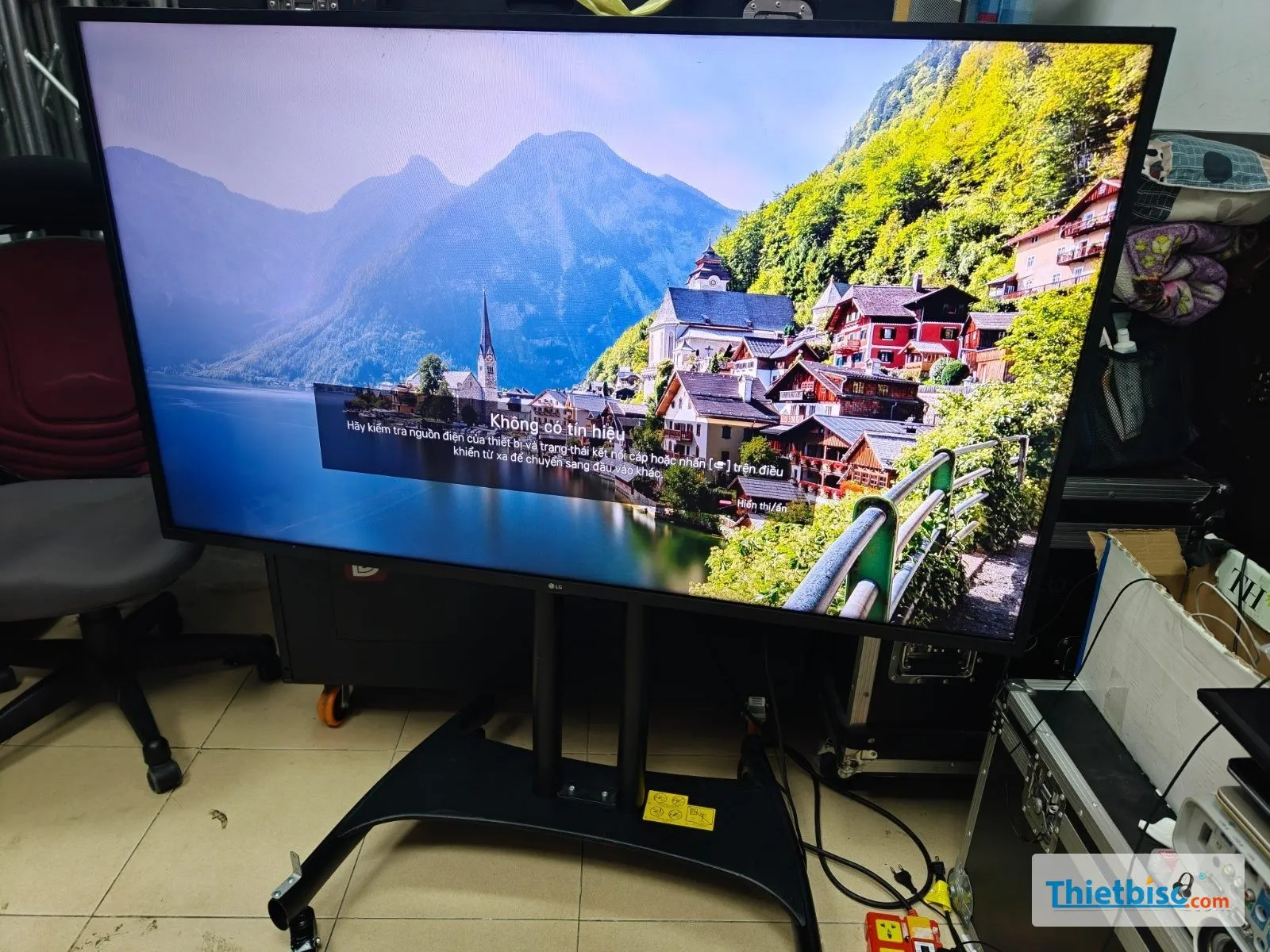 Tivi LG trên chân di động bánh xe trong kho, màn hình báo không có tín hiệu
