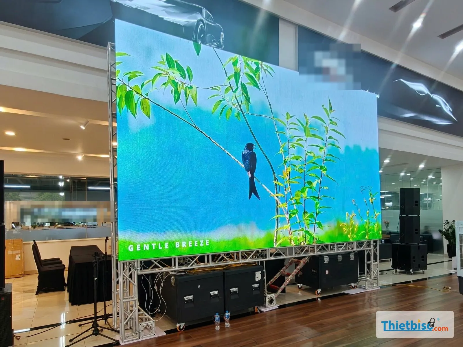 Màn LED dựng trên khung truss với vali thiết bị và dàn loa