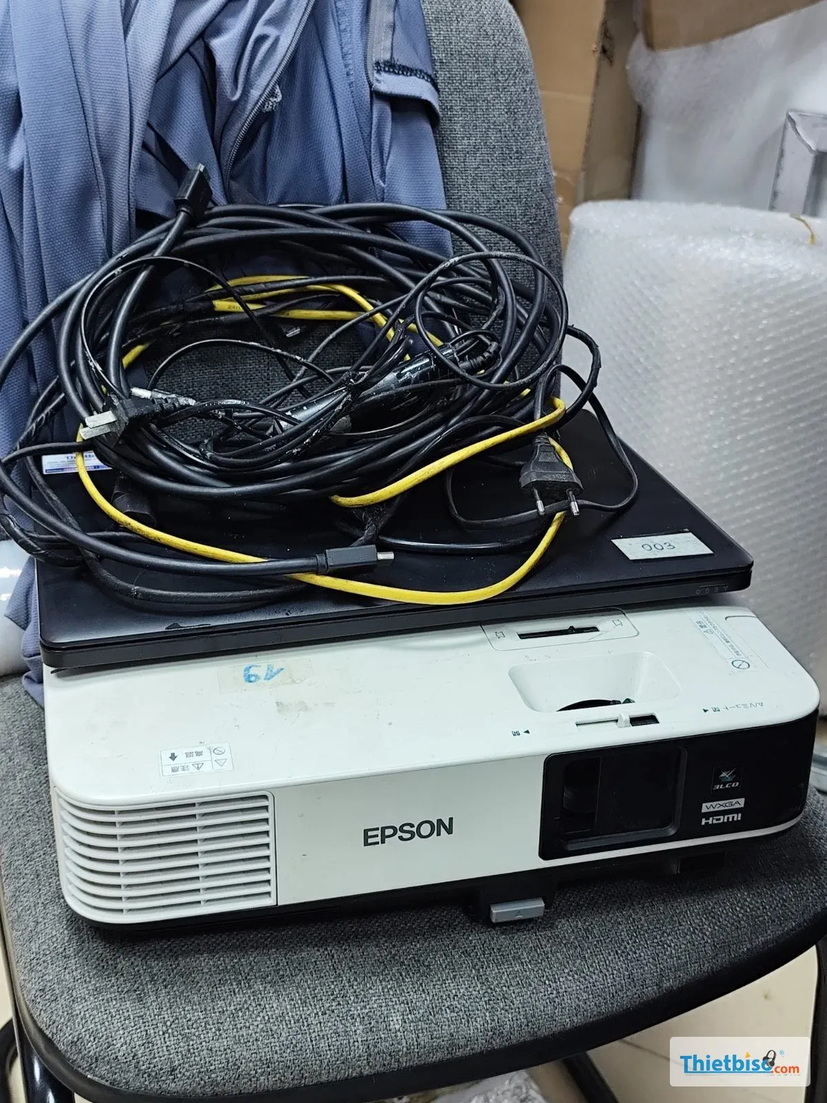 Máy chiếu Epson, laptop và dây cáp xếp trên ghế sau khi thu hồi