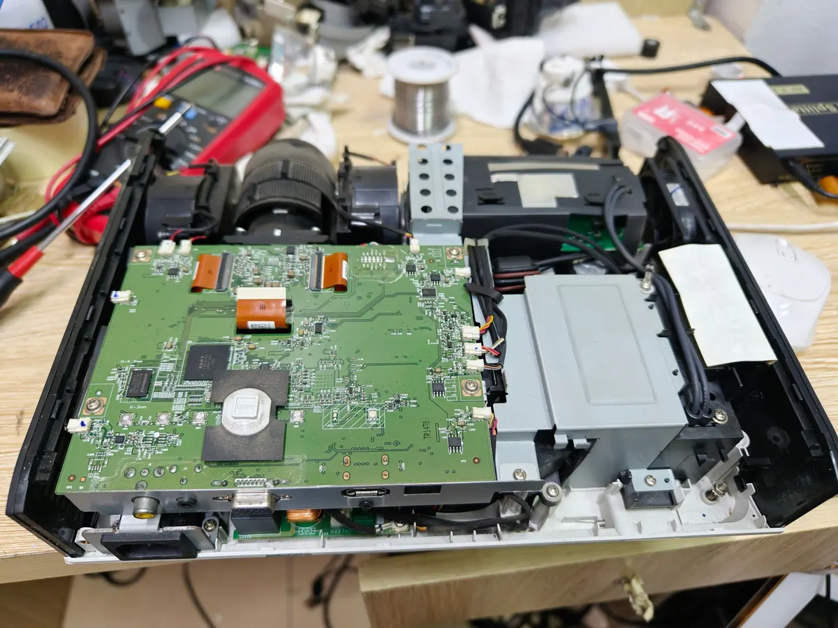 Máy chiếu Sony tháo nắp để lộ bo mạch chính cạnh khối quang học trên bàn sửa