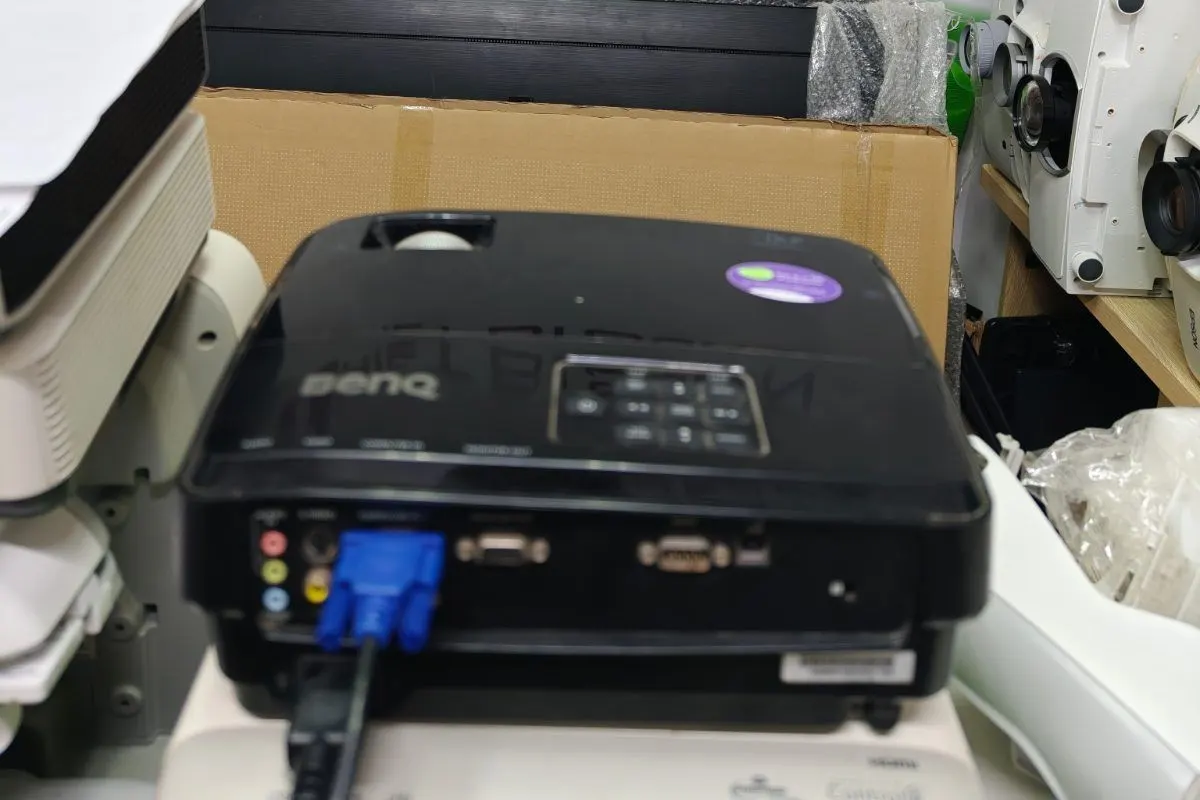 Máy chiếu BenQ cắm cáp VGA đang được kiểm tra lỗi hình chiếu bị mờ