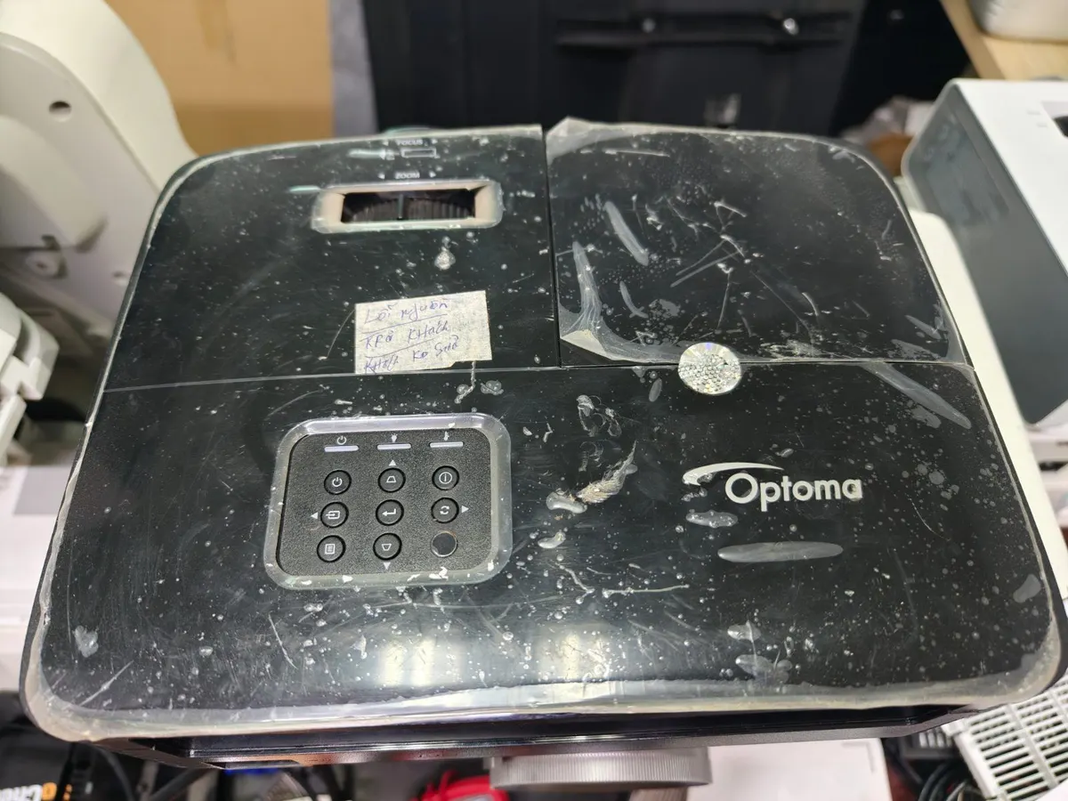 Máy chiếu Optoma cũ có vết trầy trên mặt trên, đang chờ kiểm tra