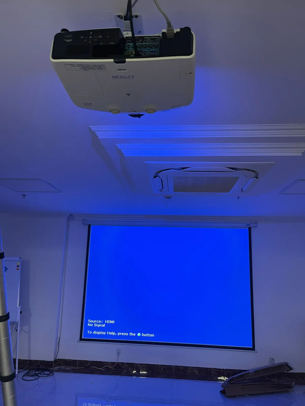 Máy chiếu Epson treo trần đối diện màn chiếu điện trong phòng hội nghị